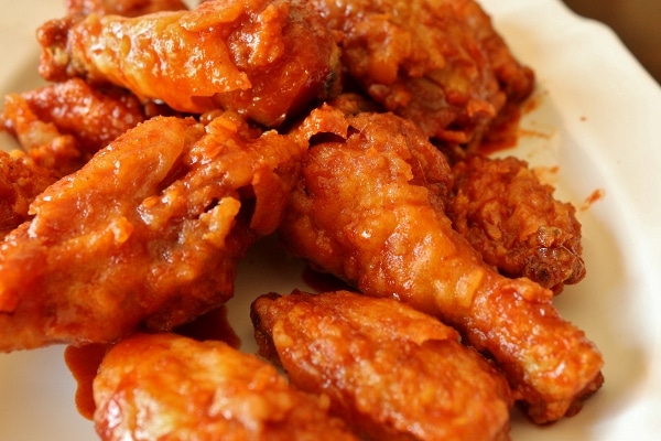 a closeup of crispy Korean fried chicken on a white platter