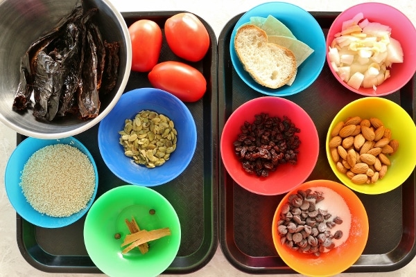 colorful bowls filled with various ingredients for mole sauce