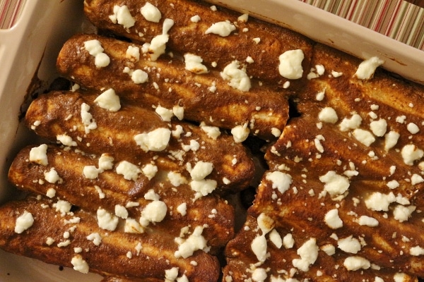 overhead view of a baking dish of enmoladas (enchiladas with mole sauce)