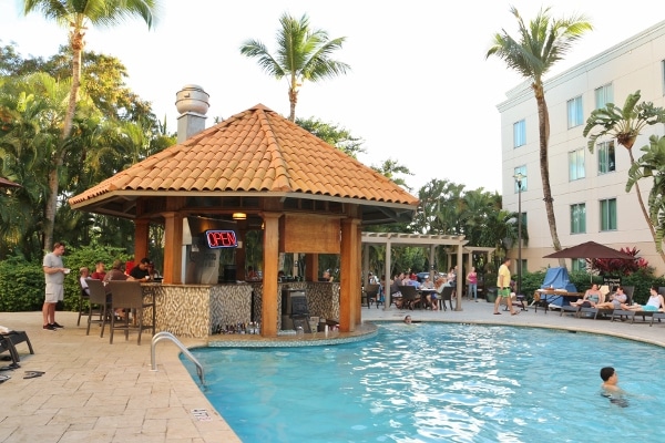 A swimming pool with a small pool bar shaped like a hut next to it