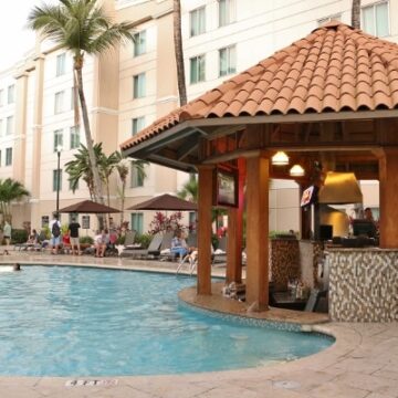 an outdoor swimming pool with a small bar and grill next to it