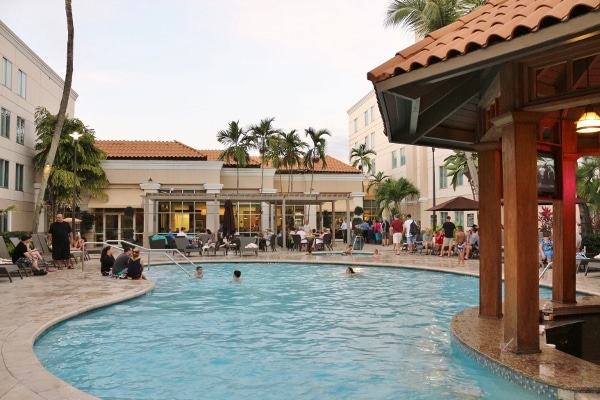 a swimming pool with a large stucco hotel building behind it