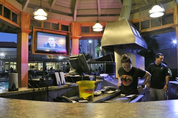 a woman in the kitchen area of an outdoor bar and grill