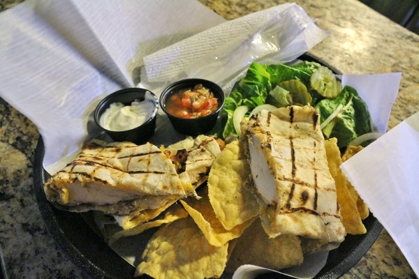 a grilled chicken quesadilla served with tortilla chips and salad