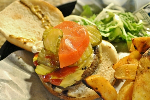 sliced pickles and tomato on a cheeseburger