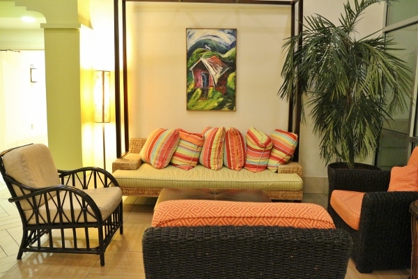 a sitting area in a hotel lobby with colorful pillows