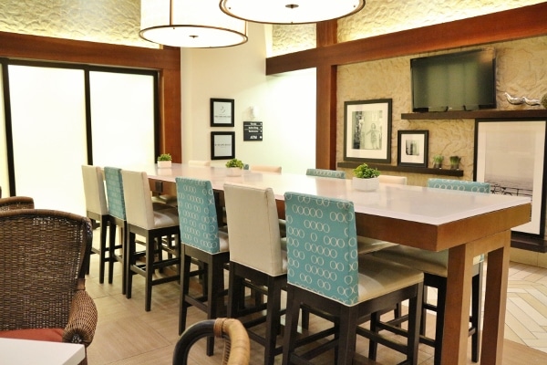 A dining room table with colorful chairs