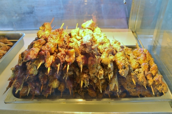a pile of skewered meats in a glass display