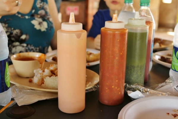 sauces of different colors in plastic squeeze bottles on a table