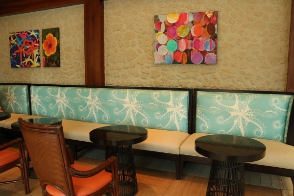 a booth sitting area with brightly colored cushions and wall paintings