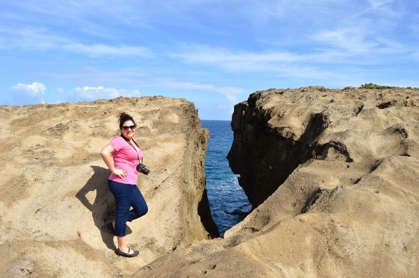 A woman standing in front of a rock