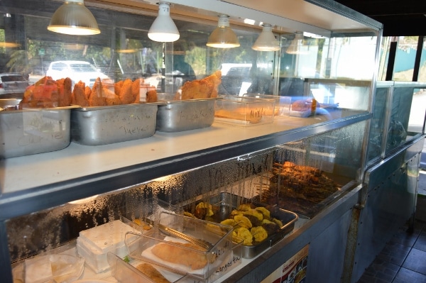 various foods for sale on display behind a glass wall