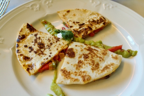 a vegetable quesadilla served on a white plate