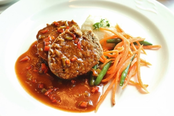 meatloaf served with a brown gravy and vegetables