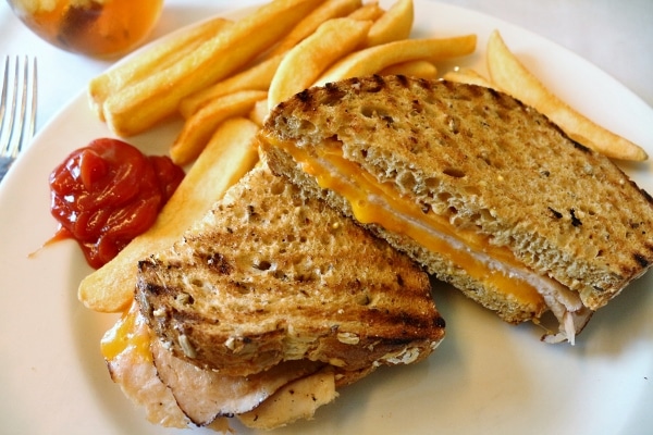 a turkey melt sandwich with fries and ketchup on a plate