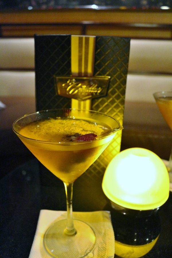 A cocktail on a dark bar table