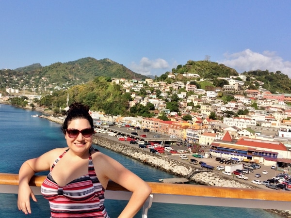 A woman posing on a cruise ship with Grenada in the background