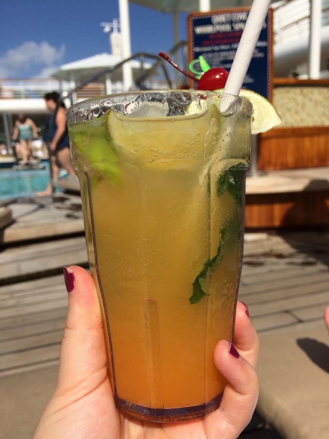 a hand holding a tropical cocktail in a glass