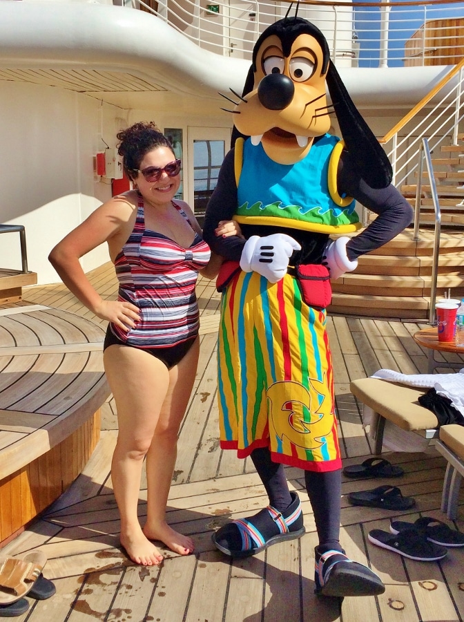 A woman in a bathing suit posing with Goofy, who is also in a bathing suit
