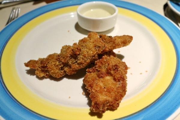 fried chicken fingers on a plate with a side of sauce