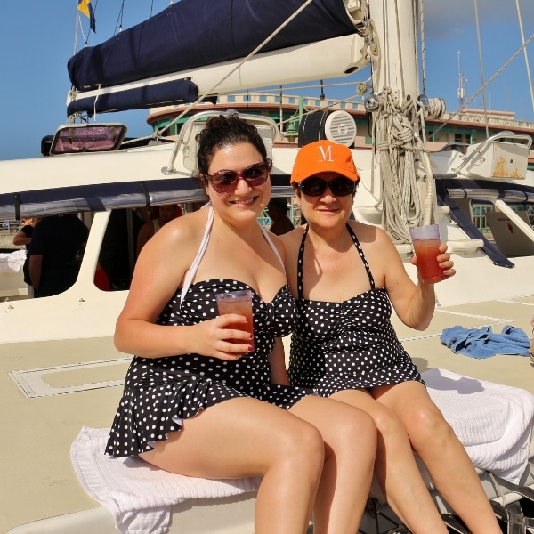 two women in matching polka dot bathing suits sitting on a catamaran
