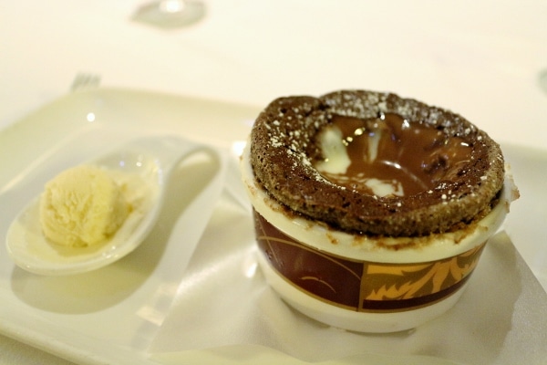 A chocolate chocolate souffle with a scoop of ice cream on the side