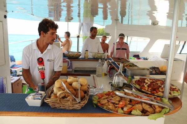 A group of people serving a buffet of food on a boat