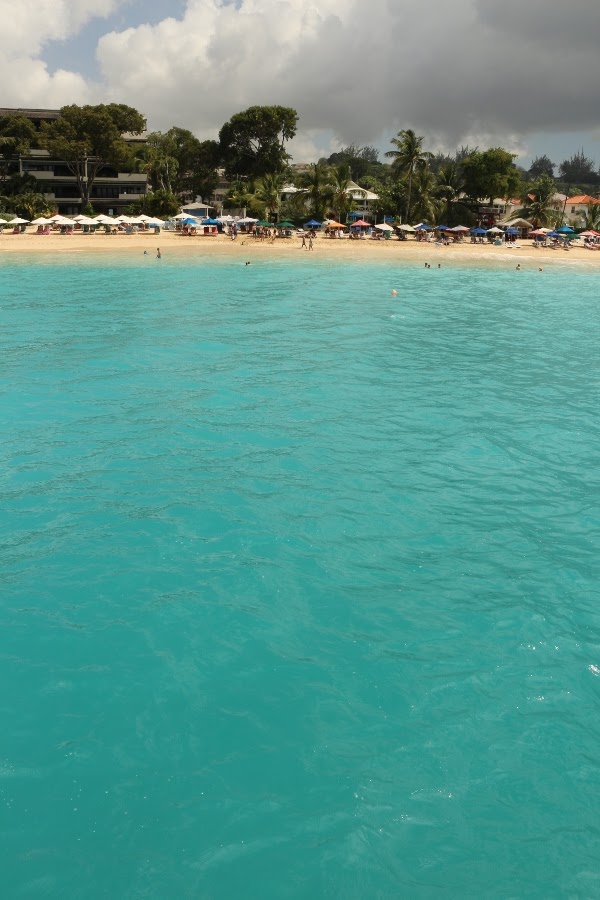 view of a beach with turquoise water from a boat
