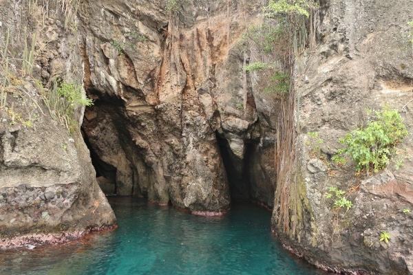 rocky cave openings on the side of a small island
