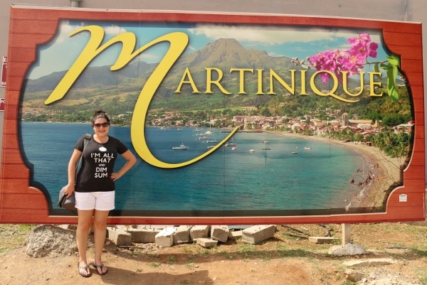 a woman posing in front of a sign that says Martinique