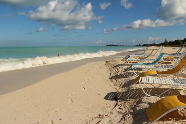 an empty sandy beach with beach chairs