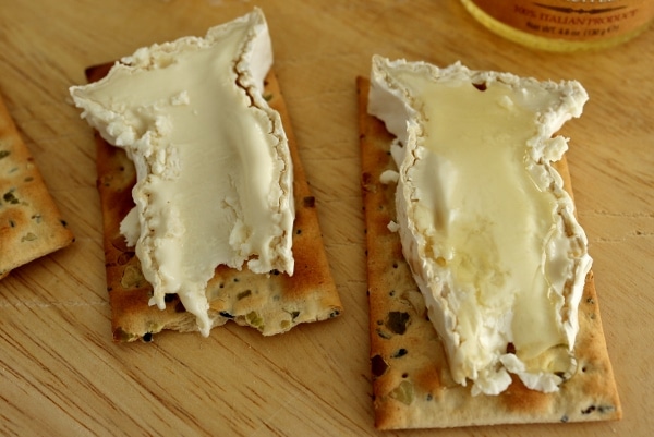 a closeup of two slices of Camembert cheese on crackers