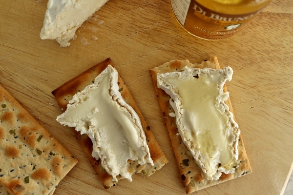 overhead view of two slices of ripe Camembert cheese on crackers