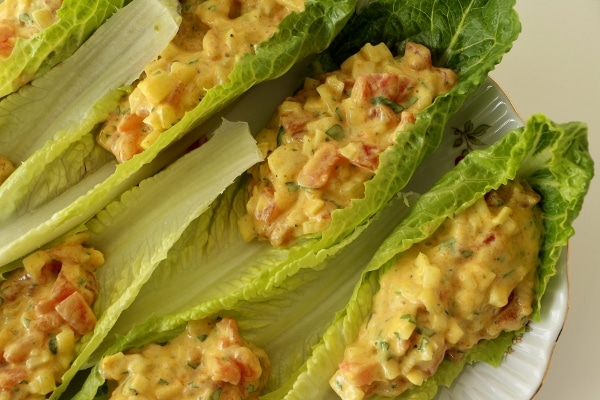 A plate of romaine lettuce cups filled with curried tomato salad.