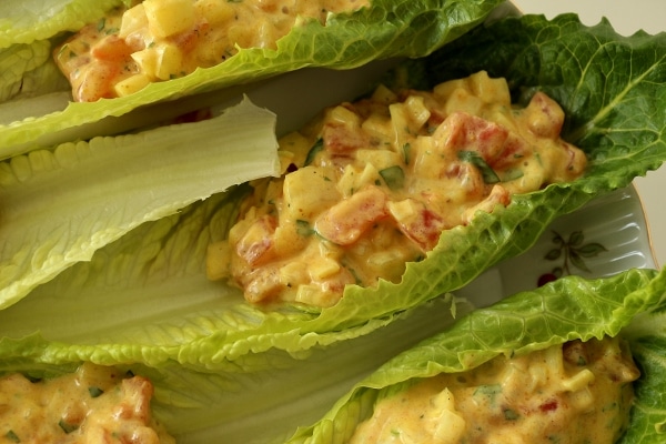 A close up of a romaine lettuce cup filled with curried tomato salad.