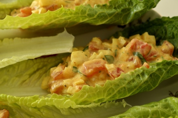 A close up of curried tomato salad served in a romaine lettuce leaf.