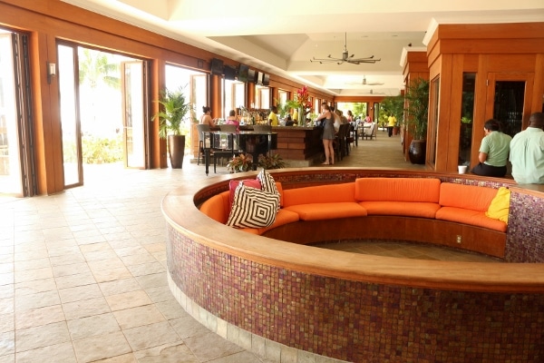 A large room a round sitting area with orange cushions