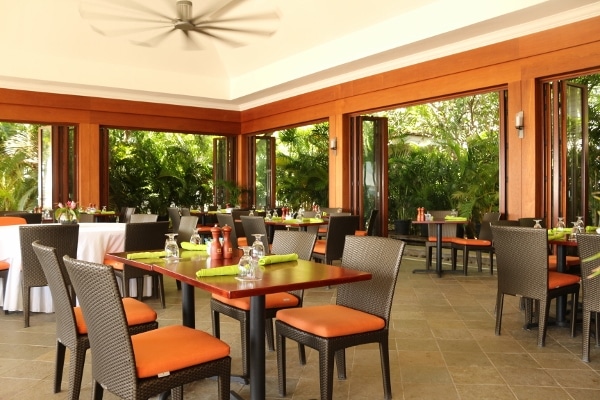 A restaurant dining room with large open windows