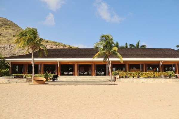 A beach with palm trees in front of a building