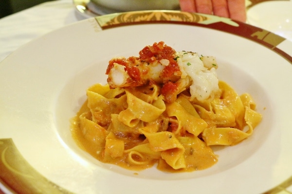 A plate of wide pasta noodles topped with lobster