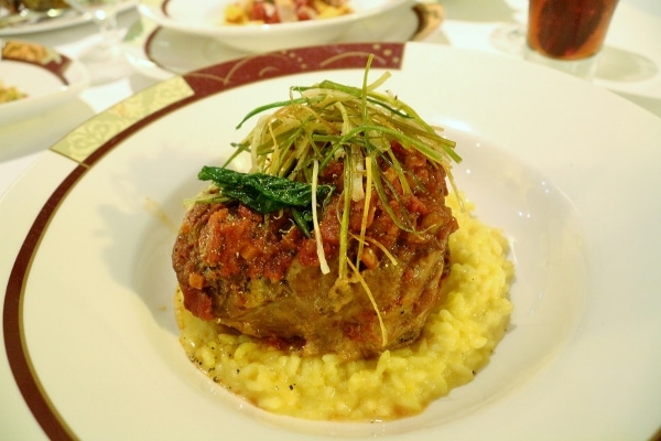 a plate of Osso Bucco served over risotto Milanese