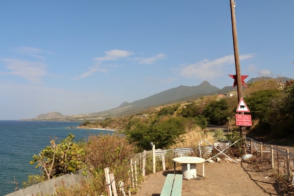 a roadside view on a shore with mountains in the distance