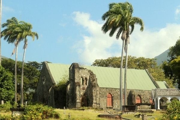 an old stone church with palm trees in front