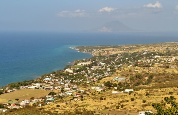 view of towns in St. Kitts by the shore, with another island in the distance