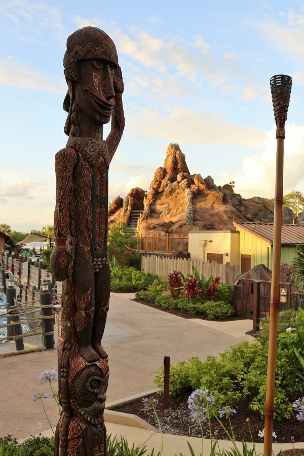 a tiki statue with a fake volcano in the background