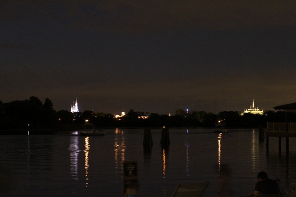 view of the Magic Kingdom at night from across a body of water