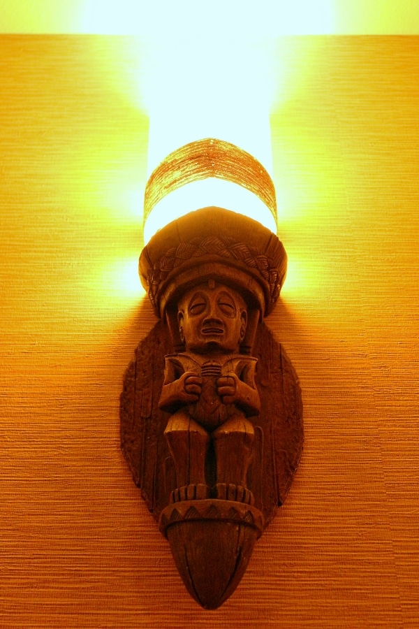 a tiki style wood carved lighting fixture