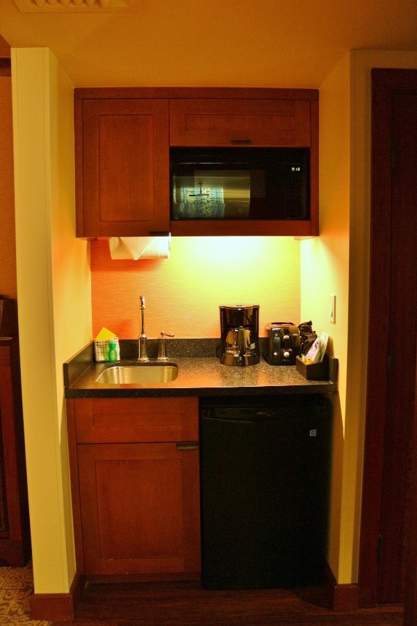 A small kitchenette with a mini fridge, sink and microwave