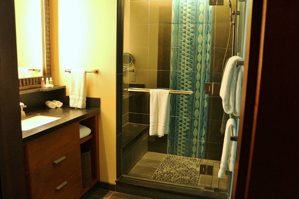 A bathroom with a standing shower and sink