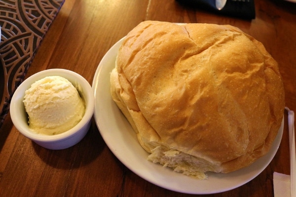 A large round loaf of bread with a scoop of butter on the side